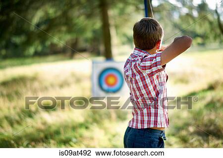 Rear view of teenage boy practicing archery with target View Large Photo Image Stock Image - Rear view of teenage boy practicing archery with target. Fotosearch