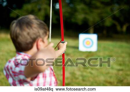 Rear view of teenage boy practicing archery View Large Photo Image Stock Photography - Rear view of teenage boy practicing archery. Fotosearch