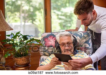 Senior man and grandson looking at digital tablet View Large Photo Image Stock Photo - Senior man and grandson looking at digital tablet. Fotosearch