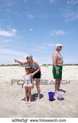 Senior woman with granddaughter pointing and looking out on beach View Large Photo Image Stock Image - Senior woman with granddaughter pointing and looking out on beach. Fotosearch