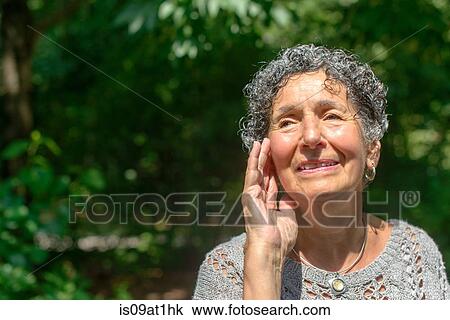 Senior woman with hand on face in park View Large Photo Image Stock Image - Senior woman with hand on face in park. Fotosearch