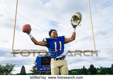 Stock Photo - Teenage American football player celebrating on soccer pitch. Fotosearch