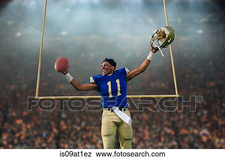 Stock Photo - Teenage American football player celebrating victory in soccer stadium. Fotosearch