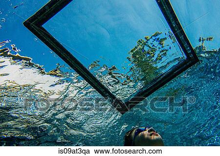 "Teenage girl underwater, looking through frame on water surface" View Large Photo Image Stock Image - "Teenage girl underwater, looking through frame on water surface". Fotosearch