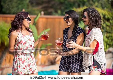 Three adult sisters gossiping and drinking rose wine in garden View Large Photo Image Picture - Three adult sisters gossiping and drinking rose wine in garden. Fotosearch