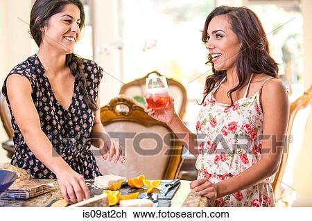 Two adult sisters drinking rose wine and snacking from cheeseboard View Large Photo Image Stock Image - Two adult sisters drinking rose wine and snacking from cheeseboard. Fotosearch