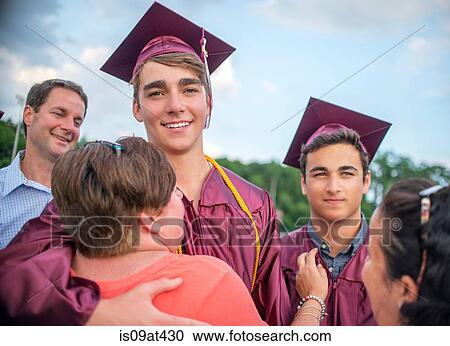 Two young men hugging family at graduation ceremony View Large Photo Image Stock Image - Two young men hugging family at graduation ceremony. Fotosearch