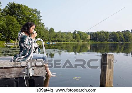 "Woman wrapped in blanket sitting on lake pier, New Milford, Pennsylvania, USA" View Large Photo Image Stock Photography - "Woman wrapped in blanket sitting on lake pier, New Milford, Pennsylvania, USA". Fotosearch