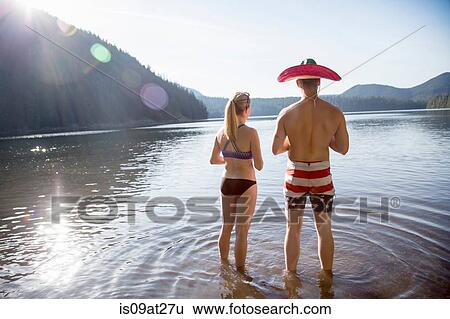 Stock Photograph - "Young couple in lake, man wearing hat, Lost Lake, Oregon, USA". Fotosearch