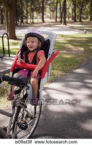 "Young girl sitting in child's bicycle seat, enjoying journey" View Large Photo Image Stock Image - "Young girl sitting in child's bicycle seat, enjoying journey". Fotosearch