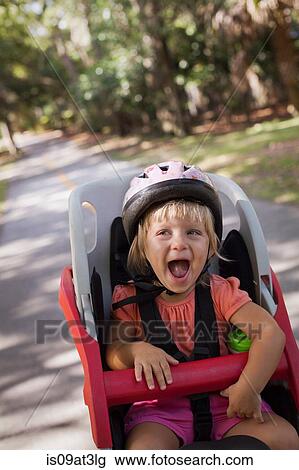 "Young girl sitting in child's bicycle seat, enjoying journey" View Large Photo Image Stock Image - "Young girl sitting in child's bicycle seat, enjoying journey". Fotosearch
