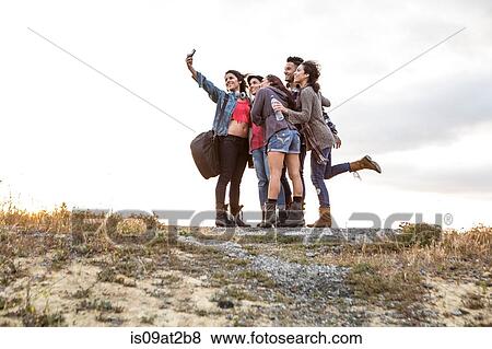 Young man and four adult sisters posing for smartphone selfie on dirt track View Large Photo Image Stock Photo - Young man and four adult sisters posing for smartphone selfie on dirt track. Fotosearch