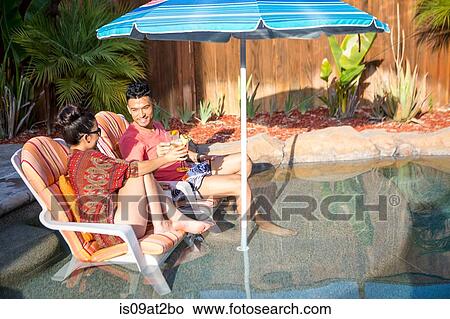 Young man and sister chatting on garden lounge chairs View Large Photo Image Picture - Young man and sister chatting on garden lounge chairs. Fotosearch