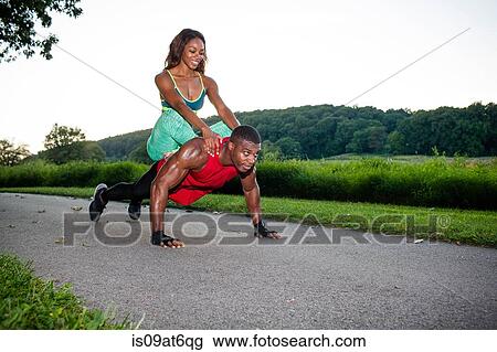 Young man doing pushups on rural road whilst giving girlfriend a piggyback View Large Photo Image Stock Image - Young man doing pushups on rural road whilst giving girlfriend a piggyback. Fotosearch