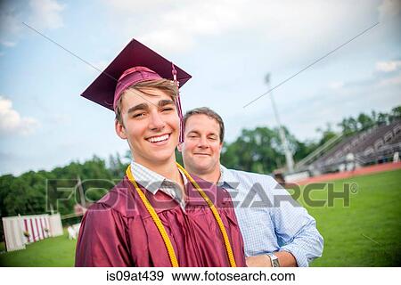 Young man standing with father at graduation ceremony View Large Photo Image Stock Photo - Young man standing with father at graduation ceremony. Fotosearch