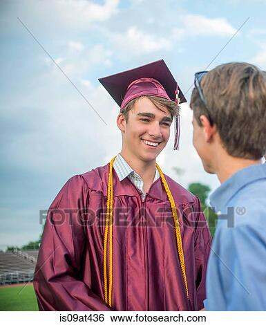 Stock Photograph - Young man with family memeber at graduation ceremony. Fotosearch