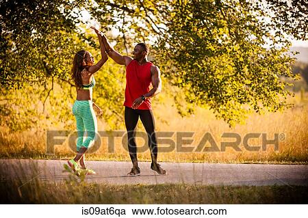 Young running couple giving high fives in park View Large Photo Image Stock Image - Young running couple giving high fives in park. Fotosearch