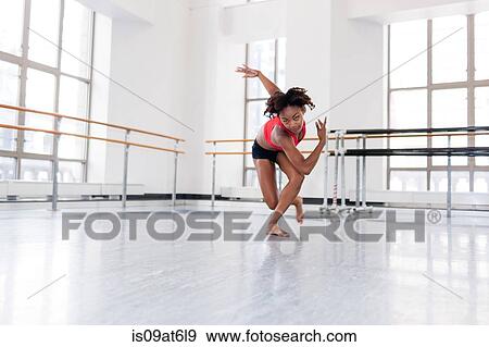 Young woman in dance studio dancing looking at camera View Large Photo Image Stock Photo - Young woman in dance studio dancing looking at camera. Fotosearch