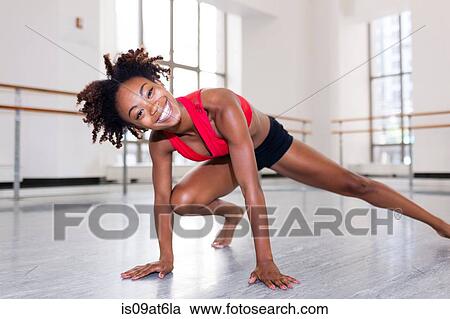 "Young woman in dance studio resting on hands, leg outstretched looking at camera smiling" View Large Photo Image Stock Image - "Young woman in dance studio resting on hands, leg outstretched looking at camera smiling". Fotosearch