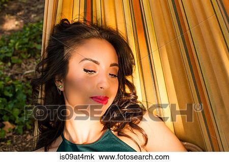 Stock Image - Young woman relaxing in hammock. Fotosearch