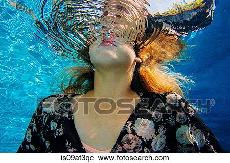 "Young woman underwater, breaking through water surface" View Large Photo Image Stock Image - "Young woman underwater, breaking through water surface". Fotosearch