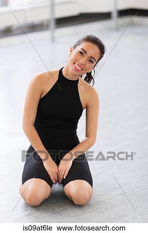 Young woman wearing lycra kneeling on ground looking at camera smiling View Large Photo Image Stock Image - Young woman wearing lycra kneeling on ground looking at camera smiling. Fotosearch