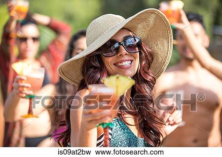Young woman wearing sunhat drinking cocktail and dancing in garden View Large Photo Image Stock Photo - Young woman wearing sunhat drinking cocktail and dancing in garden. Fotosearch