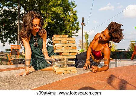 Young women playing with building blocks on floor View Large Photo Image Stock Photograph - Young women playing with building blocks on floor. Fotosearch