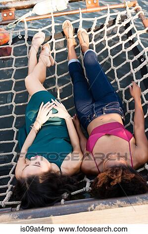 Young women relaxing in hammock View Large Photo Image Stock Photography - Young women relaxing in hammock. Fotosearch