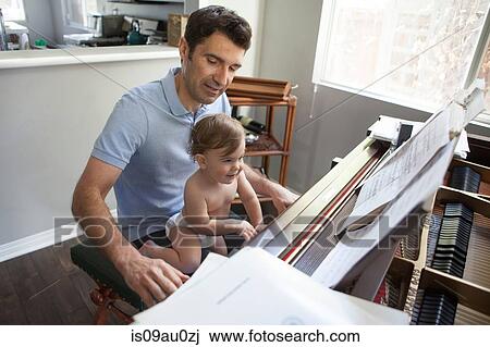 Baby boy sitting on fathers knee playing piano View Large Photo Image Stock Image - Baby boy sitting on fathers knee playing piano. Fotosearch