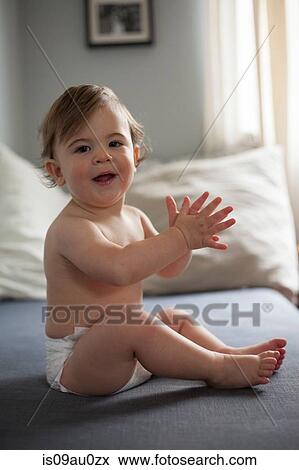 Baby boy wearing nappy clapping hands, looking at camera smiling View Large Photo Image Stock Photo - Baby boy wearing nappy clapping hands, looking at camera smiling. Fotosearch