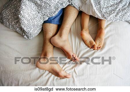 Bare feet and legs of father and young son lying in bed View Large Photo Image Stock Image - Bare feet and legs of father and young son lying in bed. Fotosearch
