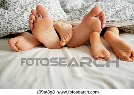 Bare feet of father and two sons lying in bed View Large Photo Image Stock Photo - Bare feet of father and two sons lying in bed. Fotosearch