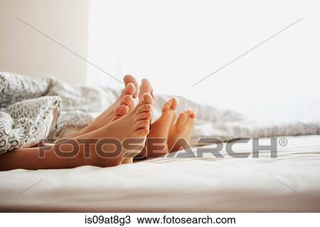 Bare feet of parents and son lying in bed View Large Photo Image Stock Image - Bare feet of parents and son lying in bed. Fotosearch