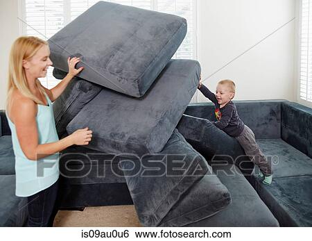 Boy pushing over cushions in living room View Large Photo Image Stock Photograph - Boy pushing over cushions in living room. Fotosearch
