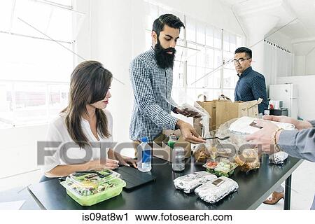 Stock Image - Business people having lunch together. Fotosearch