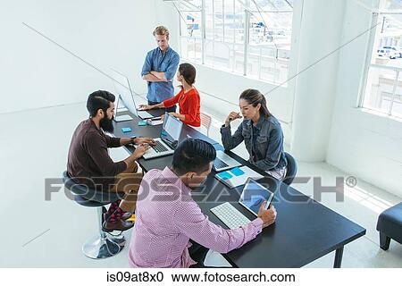 Stock Image - Business people in brainstorming meeting. Fotosearch
