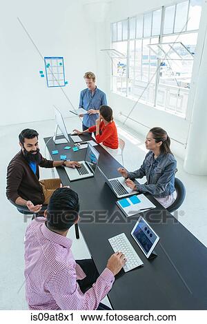 Stock Image - Business people in brainstorming meeting. Fotosearch