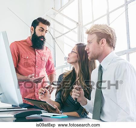 Stock Photography - Business people in brainstorming meeting by office window. Fotosearch
