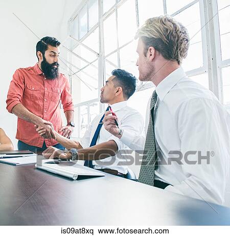 Business people in brainstorming meeting by office window View Large Photo Image Stock Photography - Business people in brainstorming meeting by office window. Fotosearch
