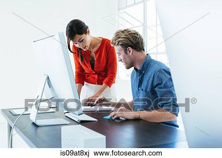 Business people working on computer by office window View Large Photo Image Stock Image - Business people working on computer by office window. Fotosearch