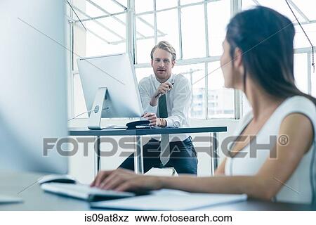 Business people working on computer by office window View Large Photo Image Stock Photo - Business people working on computer by office window. Fotosearch