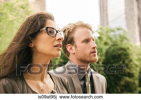 Businessman and woman in city staring View Large Photo Image Stock Image - Businessman and woman in city staring. Fotosearch