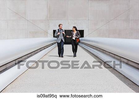 Businessman and woman talking on city walkway View Large Photo Image Stock Photography - Businessman and woman talking on city walkway. Fotosearch