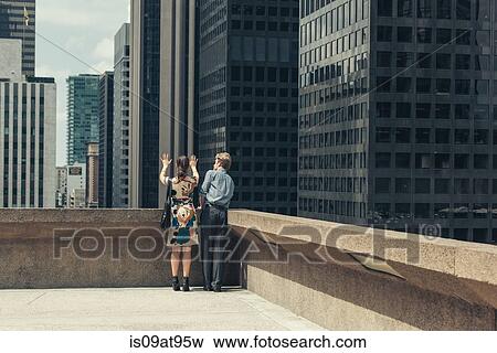 Businessman and woman talking on rooftop corner, Los Angeles, USA View Large Photo Image Stock Photo - Businessman and woman talking on rooftop corner, Los Angeles, USA. Fotosearch
