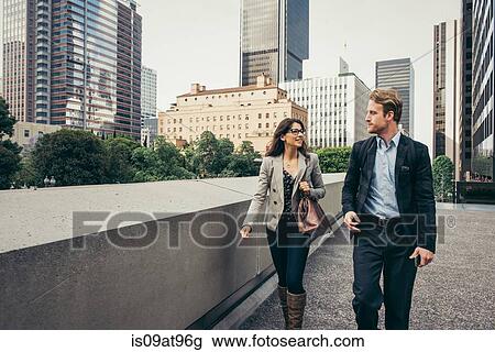 Businessman and woman walking and talking in city, Los Angeles, USA View Large Photo Image Stock Image - Businessman and woman walking and talking in city, Los Angeles, USA. Fotosearch