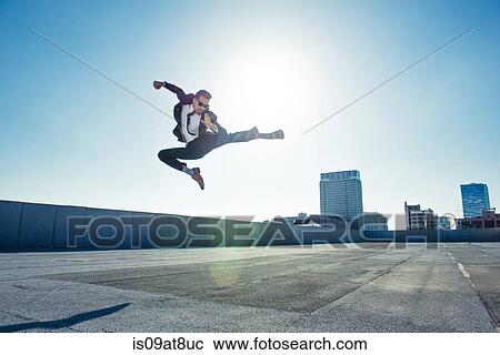 Businessman doing flying kick on roof terrace, Los Angeles, California, USA View Large Photo Image Stock Image - Businessman doing flying kick on roof terrace, Los Angeles, California, USA. Fotosearch
