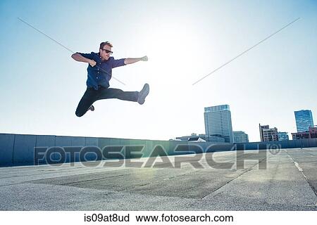 Businessman doing flying kick on roof terrace, Los Angeles, California, USA View Large Photo Image Stock Image - Businessman doing flying kick on roof terrace, Los Angeles, California, USA. Fotosearch