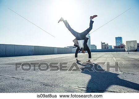 Businessman doing handstand on roof terrace, Los Angeles, California, USA View Large Photo Image Stock Image - Businessman doing handstand on roof terrace, Los Angeles, California, USA. Fotosearch