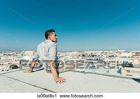 Stock Image - Businessman relaxing on roof terrace, Los Angeles, California, USA. Fotosearch